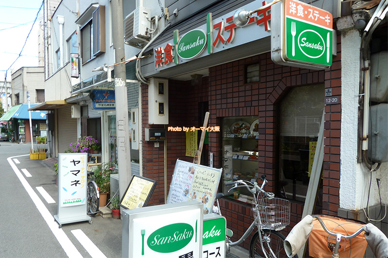 あびこの洋食店「SanSaku（サンサク）」の外観です。自転車の多さは、常連さんの多さの証明と言えるかもしれません。