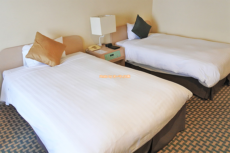 広々とした「「天王寺都ホテル」のベッド。ゆっくり休むことができます。
